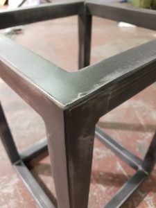 Custom distressed finish on a metal table base